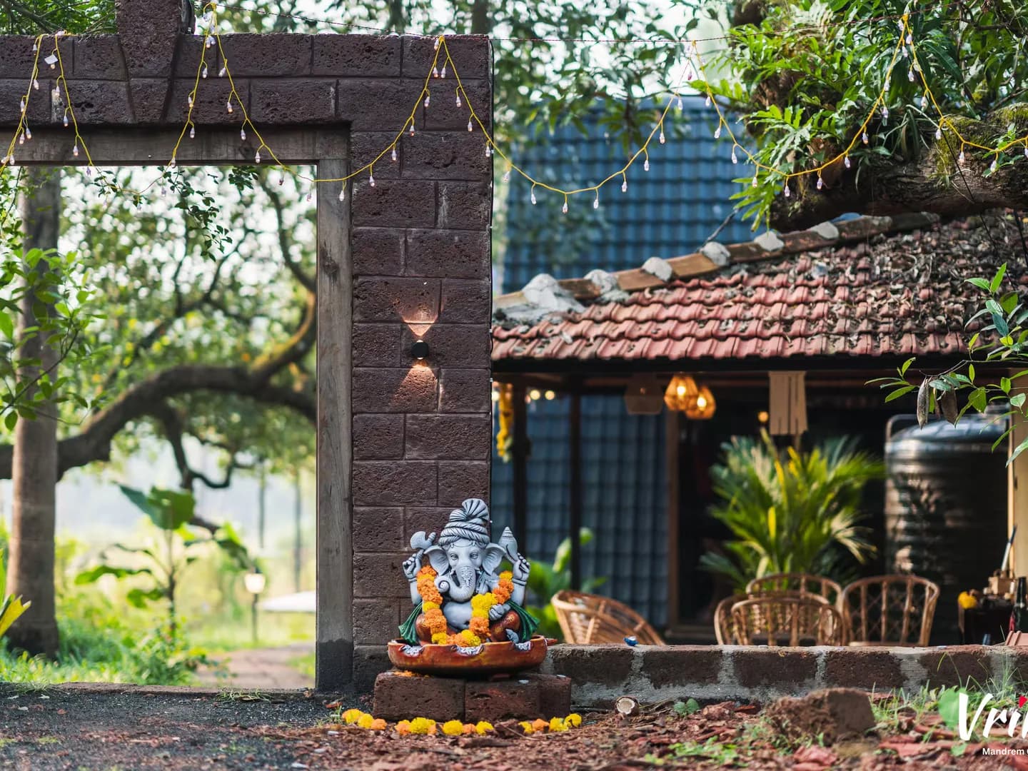 A laterite gate, marigolds, and a Ganesha